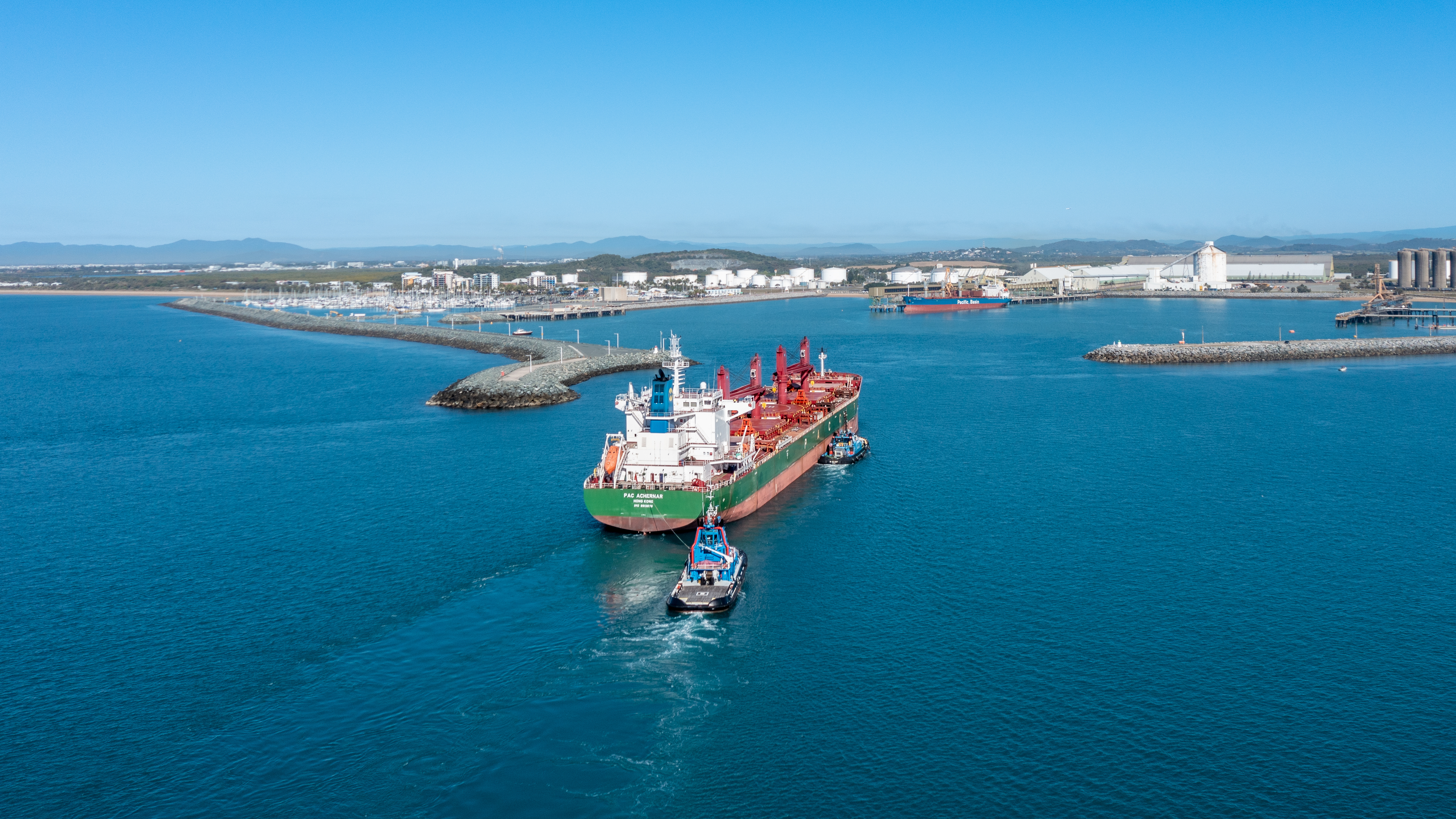 one large ship and two smaller vessels entering a port