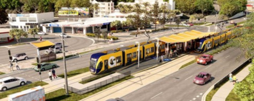 A train next to a road with cars on the Gold Coast.